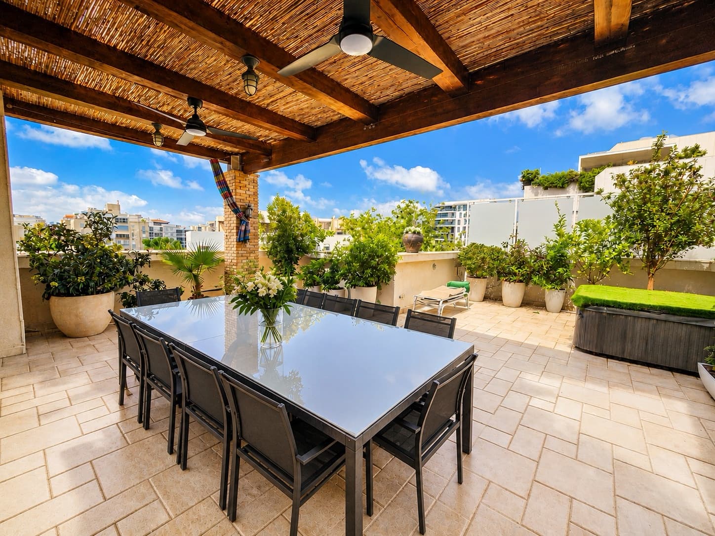 Pergola-covered main terrace with dining for ten above the rooftops of Ramat Aviv Gimmel